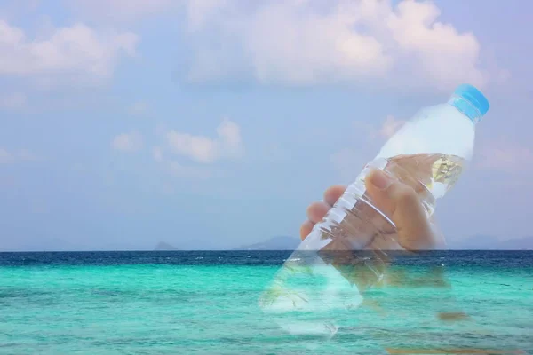 hand holding plastic bottle on sea blue sky white cloud,save sea concept.
