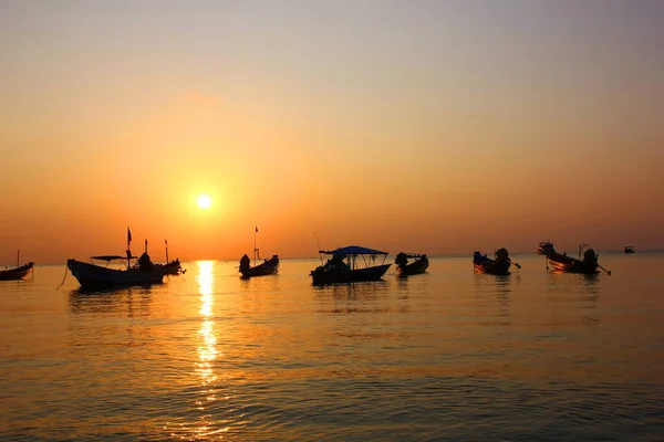 Uzun kuyruklu teknelerden oluşan siluet grubu akşam vakti turiste servis yaptıktan sonra kıyıya park ediyor..