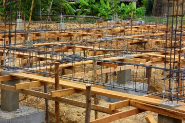 İnşaat alanındaki binanın zemin katını beton yapmak için betonla güçlendirilmiş çelik yapıyı kapatın..