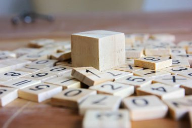 Ahşap zemindeki küçük ağaçların üzerinde numarası olan tahta küp..