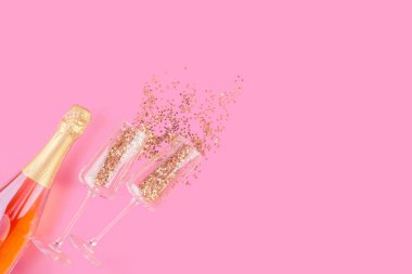 Bir şişe pembe şampanya ve Noel 'le dolu iki bardak.