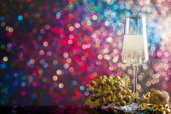 Ett glas champagne omgiven av julpynt mot — Stockfoto