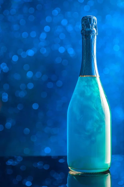 Uma garrafa de champanhe de cor azul no fundo do spa — Fotografia de Stock