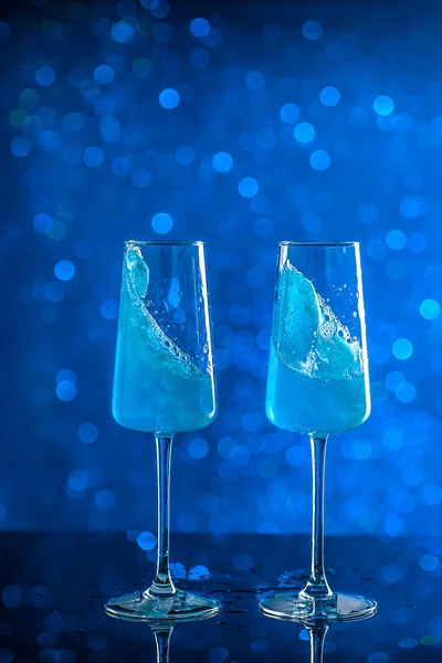 Dvě sklenice modře zbarveného šampaňského na pozadí — Stock fotografie