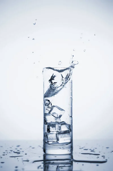 Temiz maden suyu buzlu bir bardağa sıçrar.. — Stok fotoğraf