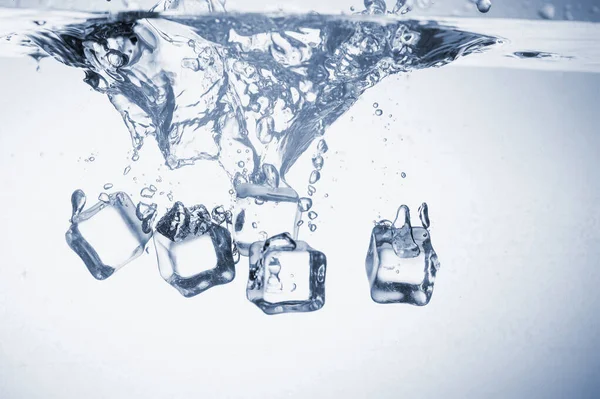 Ice cubes fall into the water. — Stock Photo, Image