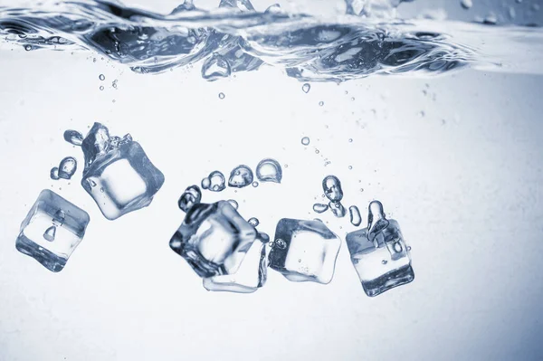 Los cubos de hielo caen al agua . —  Fotos de Stock