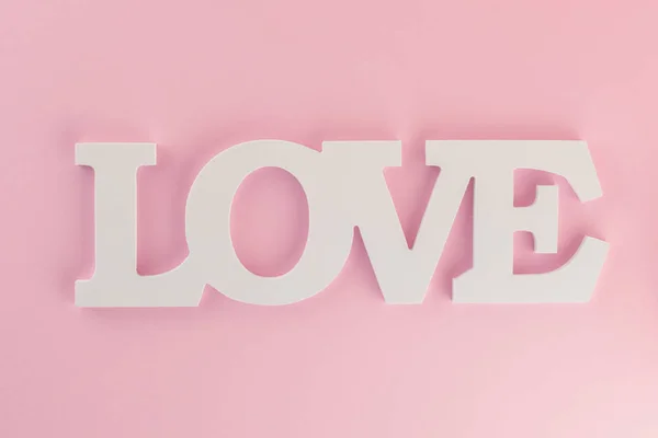 L'iscrizione "Love" su sfondo rosa pastello . — Foto Stock