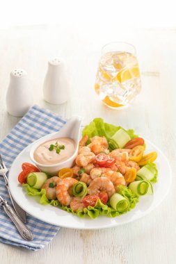 Taze marullu ızgara karides salatası, vişneli domates ve kremalı sos. Beyaz bir tabakta büyük bir porsiyon. Kapatın. Yemek hazır. Seçici odak.