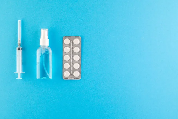 A set of hygienic antiseptics and medications on a blue background. Top view. Antibacterial protection and self-care. Stop the spread of infection. Medical hygiene and virus protection concept.