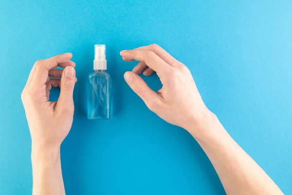 Hands hold a set of hygienic antiseptics and medications on a blue background. Antibacterial protection and self-care. Stop the spread of infection. Medical hygiene and virus protection concept.