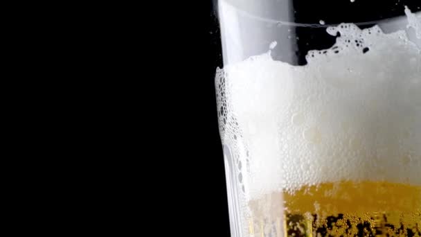 冷たいライトクラフトビールをグラスに注ぐ 黒の背景にクローズアップビデオ コピースペース Uhdビデオ3840X2160 — ストック動画