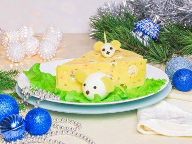 Tatil Noel salatası 2020 Yeni Yıl peyniri beyaz tabak menüsünde. Peynirli haşlanmış yumurta beyaz fareye benzer, yatay, yakın plan. Noel hediyeleri