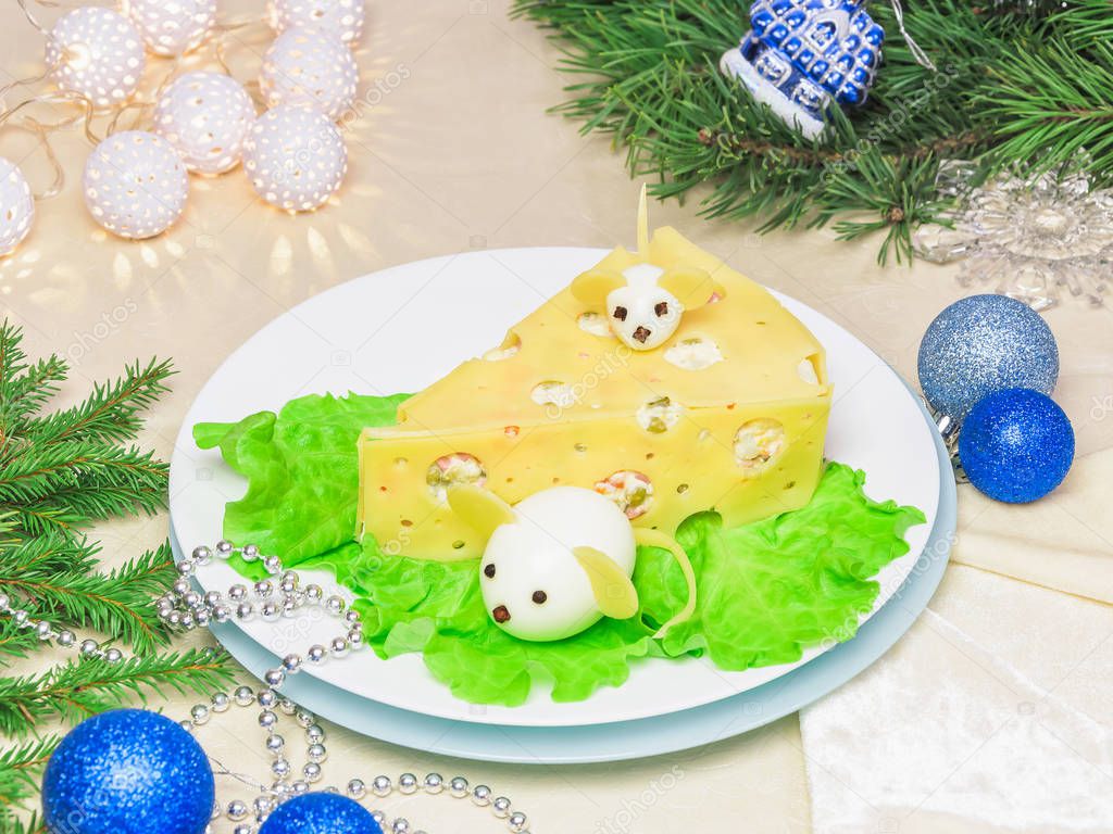 Holiday Christmas salad 2020 New Year cheese piece shape on a white plate - menu idea. Boiled eggs with cheese look like white mice (rats), horizontal. Christmas scene with lights garlands
