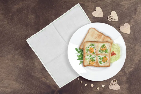 Jajecznica z jajkami i chlebem w kształcie serca z gorącymi tostami i świeżymi warzywami serwowanymi na drewnianym stole. Romantyczne śniadanie w Walentynki lub Dzień Matki — Zdjęcie stockowe