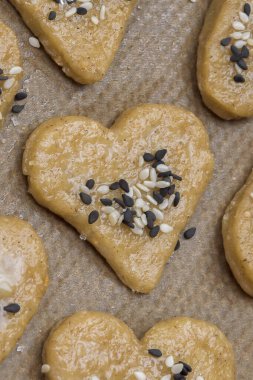 Siyah beyaz susamlı zencefilli kurabiye ve kurabiye kağıdı üzerine şeker. Ev yapımı tatlı hamur işleri sahnesi. Rustik biçim tarifi, dikey