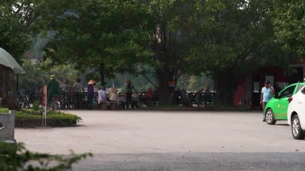 Tam Coc, Vietnam - 19th October 2019: Locals in Conical Hats gather around the river that leads through Ninh Binh — Stockvideo