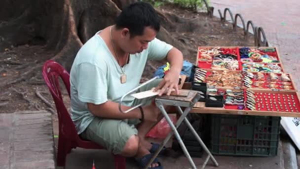 Hanoi, Vietnam - 11 de octubre de 2019: Un local construye recuerdos de madera para turistas utilizando una sierra de mano — Vídeos de Stock