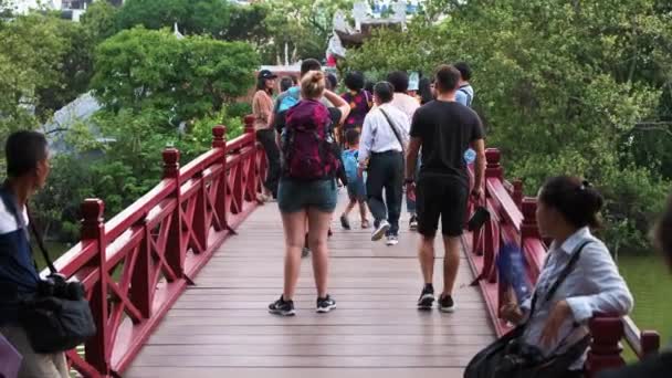 Hanoi, Vietman - 11 oktober 2019: Massor av turister går över den röda Huc Bridge på Hoan Kiem Lake i huvudstaden i Vietnam — Stockvideo