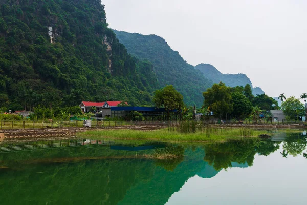 Montagnes reflétées dans un lac vert ember sur l'île cachée de Cat Ba qui est régulièrement visitée par des excursions en bateau autour de Ha Long Bay — Photo