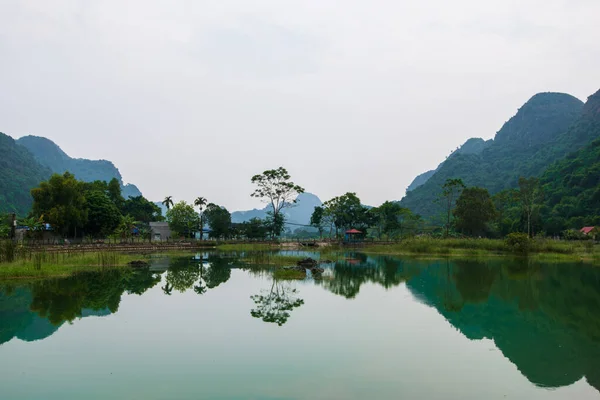 Bergen weerspiegeld in een ember groen meer op de verborgen Cat Ba Island die regelmatig wordt bezocht door boottochten rond Ha Long Bay Rechtenvrije Stockfoto's