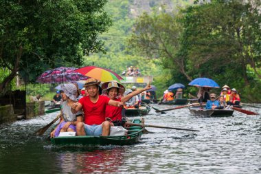 Tam Coc, Vietnam, 16 Ekim 2019: Asyalı turistler güneşli bir günde Ninh Binh 'in kireç taşı mağaralarında kürek turuna çıktılar