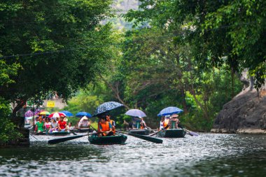 Tam Coc, Vietnam, 16 Ekim 2019: Asyalı turistler güneşli bir günde Ninh Binh 'in kireç taşı mağaralarında kürek turuna çıktılar