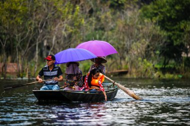 Tam Coc, Vietnam, 16 Ekim 2019: Asyalı turistler güneşli bir günde Ninh Binh 'in kireç taşı mağaralarında kürek turuna çıktılar
