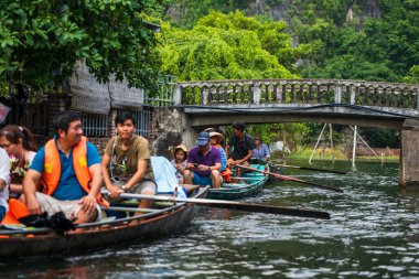 Tam Coc, Vietnam, 16 Ekim 2019: Asyalı turistler güneşli bir günde Ninh Binh 'in kireç taşı mağaralarında kürek turuna çıktılar
