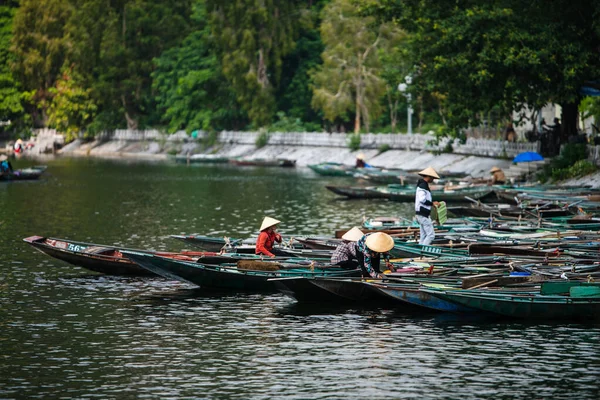 Remadores vietnamitas atan botes de remos juntos en Tam Coc, Ninh Binh en preparación para los turistas que llegan para las excursiones en barco en el río —  Fotos de Stock