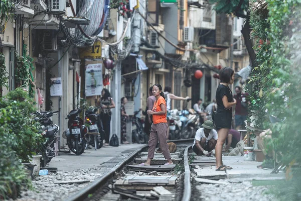Hanoi, Vietnam - 18 octobre 2019 : Des touristes prennent des photos alors qu'ils se tiennent debout sur les rails de la rue Train à Hanoi, Vietnam — Photo
