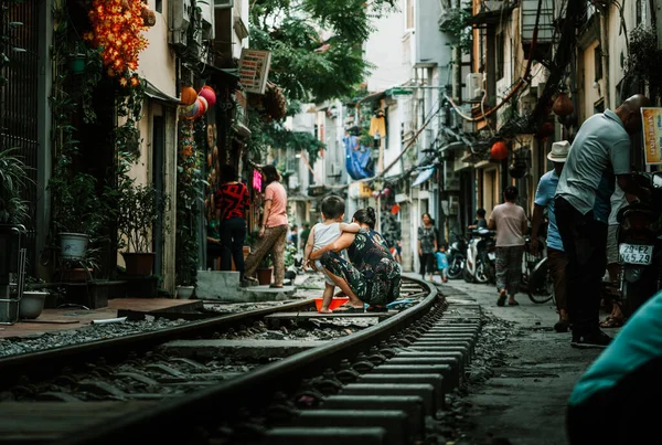 Hanoi, Vietnam - 18 oktober 2019: Een moeder baadt haar zoon in het openbaar met een bad op het spoor op de beroemde Train Street in Hanoi, Vietnam — Stockfoto