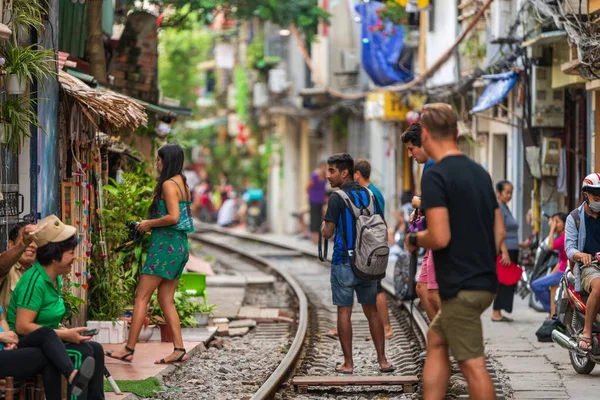 Hanoi, Vietnam - 18 octobre 2019 : Des touristes prennent des photos alors qu'ils se tiennent debout sur les rails de la rue Train à Hanoi, Vietnam — Photo