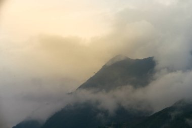Güneş doğarken Sapa 'nın güzel manzarası ve etrafındaki dağların tepeleri bulutlardan fırlıyor.