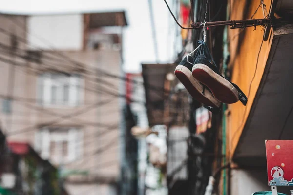 Moody tiro de zapatos colgando fuera de un edificio de apartamentos en una ciudad típica de Asia, como en Japón, Vietnam o China —  Fotos de Stock