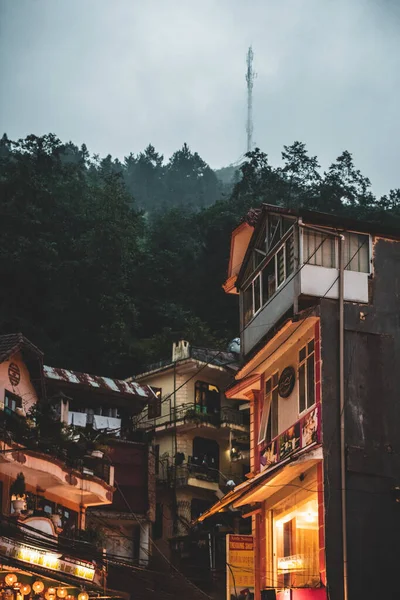 Sapa, Vietnam - 13 octobre 2019 : Bâtiments traditionnels asiatiques au pied d'une colline avec des arbres et un mât de communication en arrière-plan — Photo