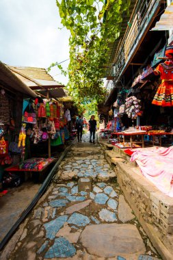 Sapa, Vietnam - 14 Ekim 2019: Kedi Köyü 'nden Vietnam' daki Sapa 'ya kadar dar bir sokak boyunca noktalanmış dükkanlarda satılık hediyeler ve hediyelikler