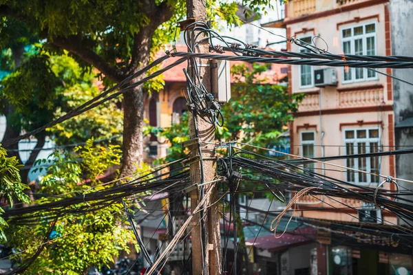 Los cables se enredaron alrededor de un poste de energía en Hanoi, Vietnam. Primer plano mostrando el desorden y el desorden que los cables plantean — Foto de Stock