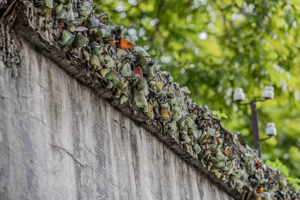 Smashed glass bottles are stuck on the top of a wall to prevent prisoners escaping from the Hanoi Hotel political prison in Vietnam — ストック写真