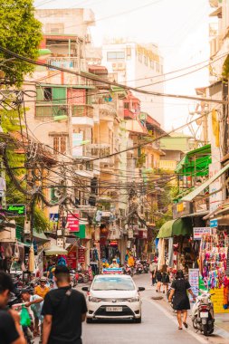 Hanoi, Vietnam - 11 Ekim 2019: Günbatımında Hanoi 'de işlek bir ara sokağa bakan güneş ve kalabalık sokaklardaki insanlar