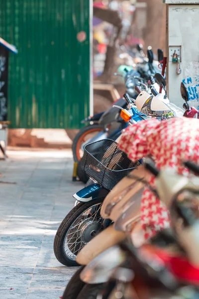 Filas de scooters coloridos, ciclomotores y bicicletas estacionadas en fila en una calle tranquila en Hanoi, Vietnam, Asia —  Fotos de Stock