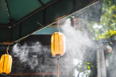 Hanoi 'nin ortasındaki Misting System, Vietnam insanları yapay soğutma sisinin altında yürürken serinletiyor.