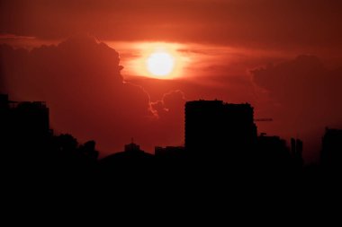 Kızıl kötülük ve tehditkar gökyüzü bulutların arkasında güneş ile gökdelenlerin üzerinde ve bir Hanoi şehri, Vietnam