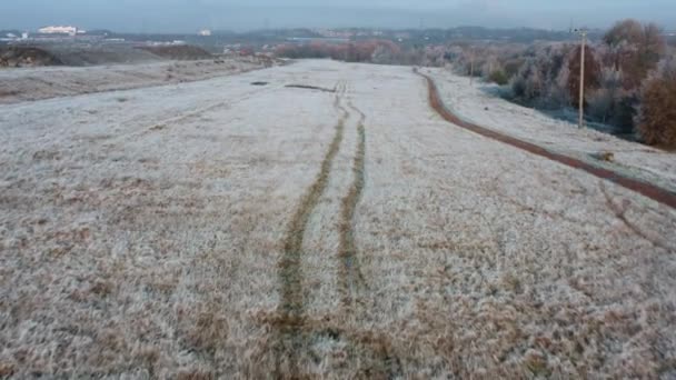 Flygdrönare som flyger över spår i fruset gräs på den nya byggarbetsplatsen Waverley i South Yorkshire under en mycket frostig soluppgång — Stockvideo