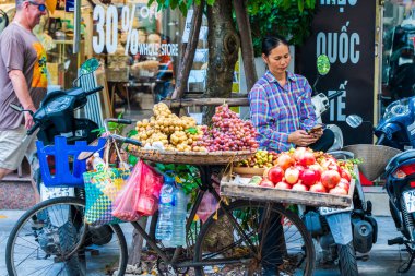Sokak yemekleri satıcısı Hanoi şehrinde bisikletle meyve satıyor.