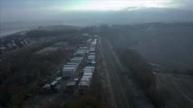 Kışın, Rotherham, Uk 'taki Waverley konutları yakınlarındaki tren rayları ve kargo üzerinde güzel, soğuk ve mavi dondurucu bir gün doğumu.