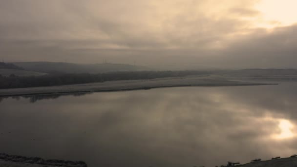 Aerial drone panning over a calm still lake reflecting the golden morning sun in the English countryside, Sheffield, South Yorkshire, UK — Stock Video