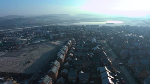 Воздушный беспилотник спускается по улице новых домов, построенных в жилом комплексе Уэверли в Ротерхэме, Южный Йоркшир, во время ледяного синего зимнего восхода солнца — стоковое видео