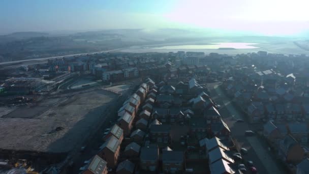 Aerial drone panning down street of new homes built on the Waverley residential estate in Rotherham, South Yorkshire during an icy blue winter sunrise — Stock Video