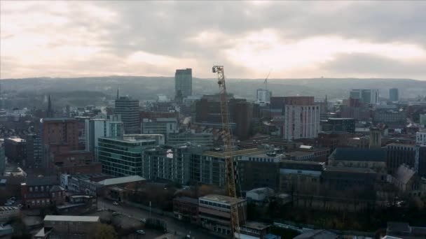 Sheffield, UK - 1st December 2019: Aerial view of a crane and construction sites around Sheffield City, South Yorkshire, during a beautiful cold sunrise — Stock Video